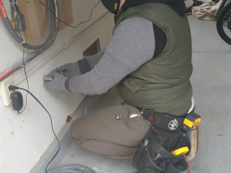 Electrician performing outlet wiring in a West Brunswick garage
